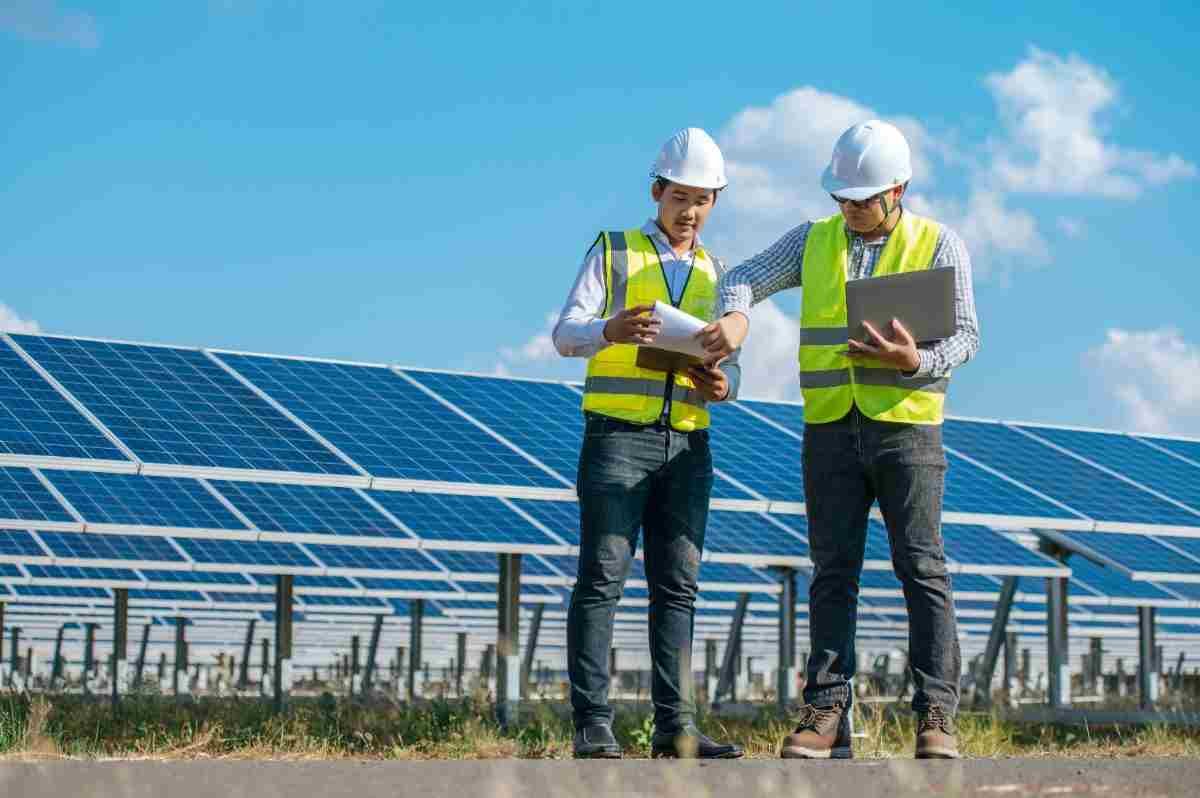 two-asian-young-engineers-walking-along-rows-photovoltaic-panels-solar-farm-they-use-laptop-com-50kb